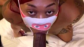 Masked performer deep throats a big black cock in POV.