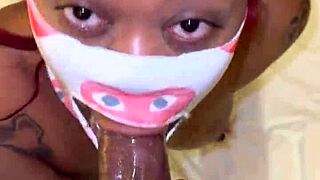 Masked performer deep throats a big black cock in POV.