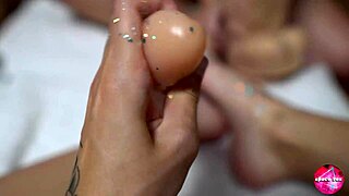 two cuties with shiny legs play with huge rubber cock footjob