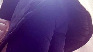 Confident 40-year-old woman tries on tight jeans in clothing store, showcasing her exaggerated curves.