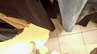 Confident 40-year-old woman tries on tight jeans in clothing store, showcasing her exaggerated curves.