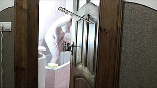 Does this naked sexy blonde in the bathroom notice her pervert roommate watching her masturbate and cum?