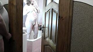 Does this naked sexy blonde in the bathroom notice her pervert roommate watching her masturbate and cum?