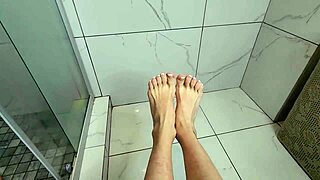Milf gives early morning footjob on cock during steamy shower bath session