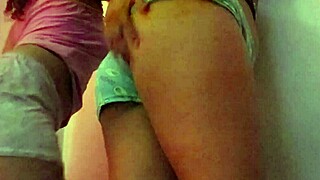 Two lesbians kiss passionately while shaking their asses seductively for the camera.