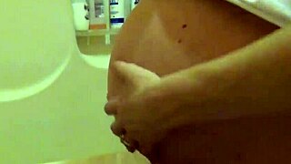 blonde pregnant beauty gets belly oiled in steamy shower massage